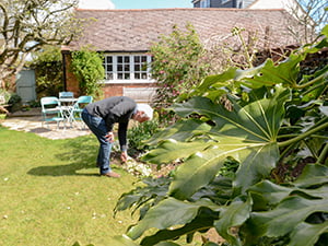  Older man landscaping his home in the spring